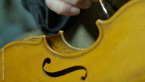 Obraz na plátně Skilled luthier applying traditional varnish technique on violin, carefully brus