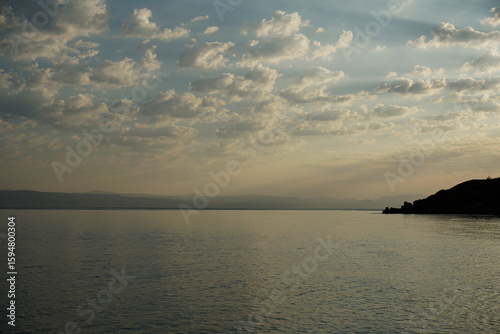 Early morning on the Aegean Sea in July. Bright colorful sunrise and clouds. Light and shadows