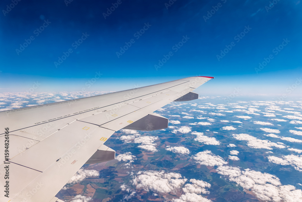 Obraz premium View from the airplane window at a beautiful cloudy sky and the airplane wing