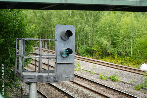 Codnor, Derbyshire, England – July 16 2025: Railway signal light and tracks under bridge in Codnor Woodland.