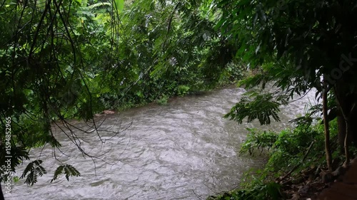 Water stream in a canal flowing down while it's raining