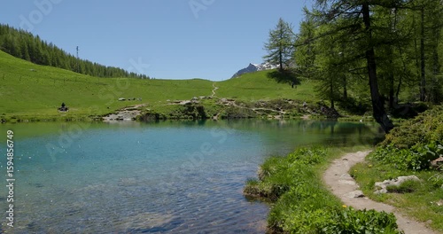 Discovering serene blue waters in the lush green mountains of a tranquil alpine valley