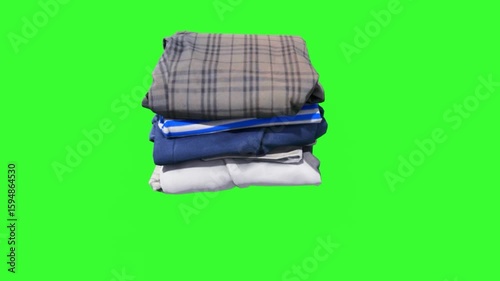 A neat stack of folded clothes in various colors and patterns on a green screen. Suitable for fashion, retail, and laundry-themed projects, ideal for compositing.