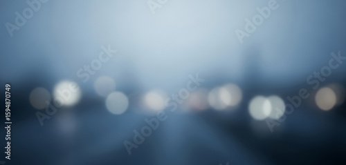 Blurred city lights in fog or rain abstract background with blue tint, creating a moody and cinematic feel perfect for urban posters, night-themed branding, or ambient visual stories.
