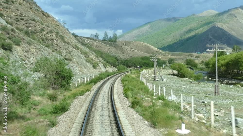 Rails, a railway and a mountain landscape, a view from the back window of the last waggon of a moved train. Rails, a railway and a mountain landscape, a view from the back window of the last waggon of a moved train.