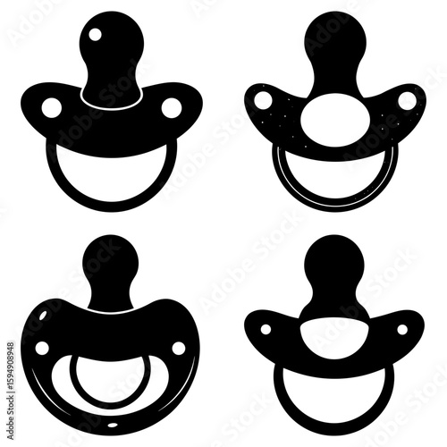 Four black and white pacifiers arranged in a square pattern with varying designs and shapes displayed