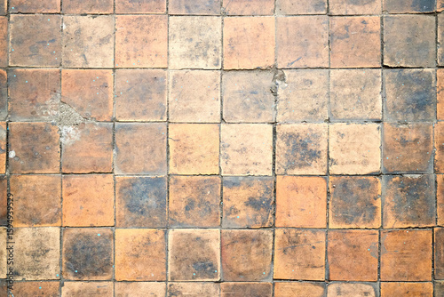 Orange brown white beige old shabby worn out floor tiles with damages cracks dirt caverns potholes and paint stains. Art design background texture.