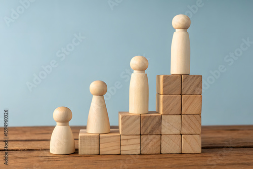 Wooden Figures Climbing a Staircase of Blocks Representing Success and Growth Illustrating Career Progression Leadership and Achievement on a Wood Surface Against a Blue Background