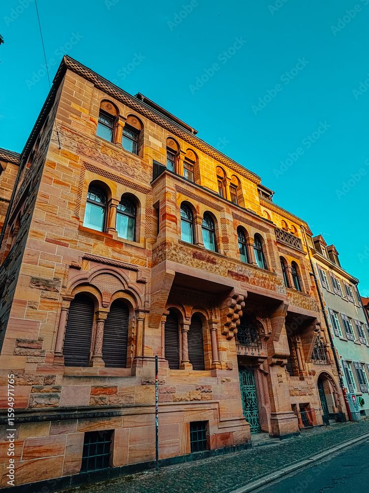 Fototapeta premium Old architectural building in city against blue bright sky. Cityscape