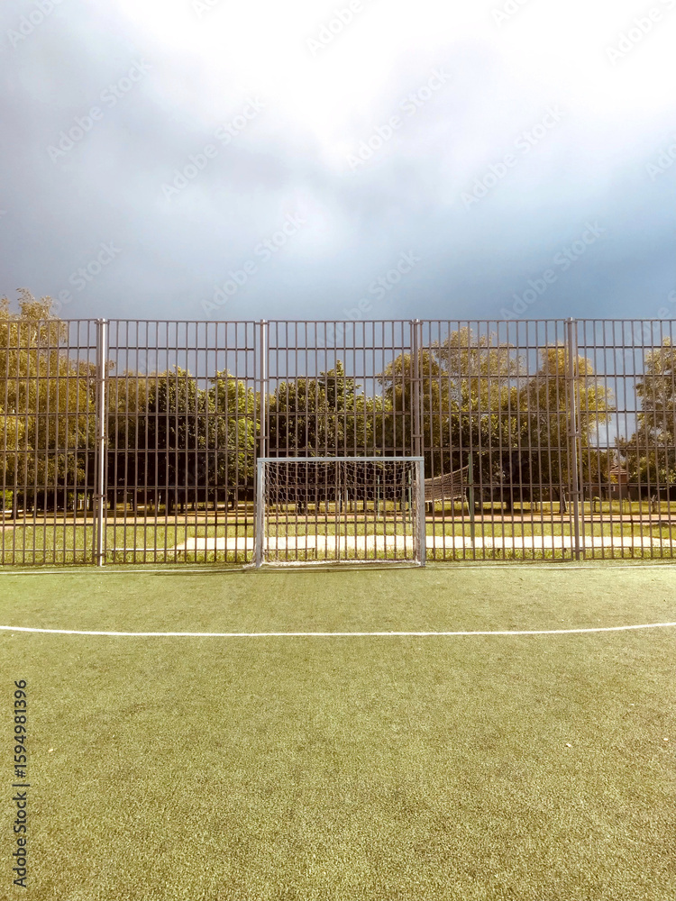 Fototapeta premium Soccer goal on a field under a cloudy sky at dusk