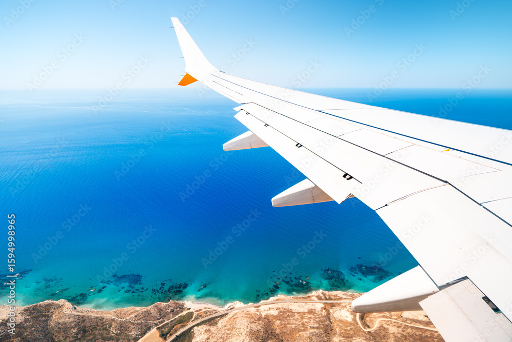 Fototapeta premium Turquoise sea seen from the wing of an airplane, island of Cyprus.