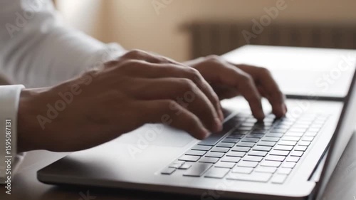 Close-up of a businessman's hands typing on a laptop keyboard. Professional man working online, using a computer in an office or for remote work.