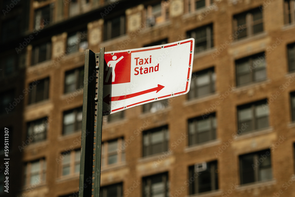 Naklejka premium Urban taxi stand sign prominently displays pictogram of person and directional arrow. Bright daylight enhances informative and functional mood of city street setting.
