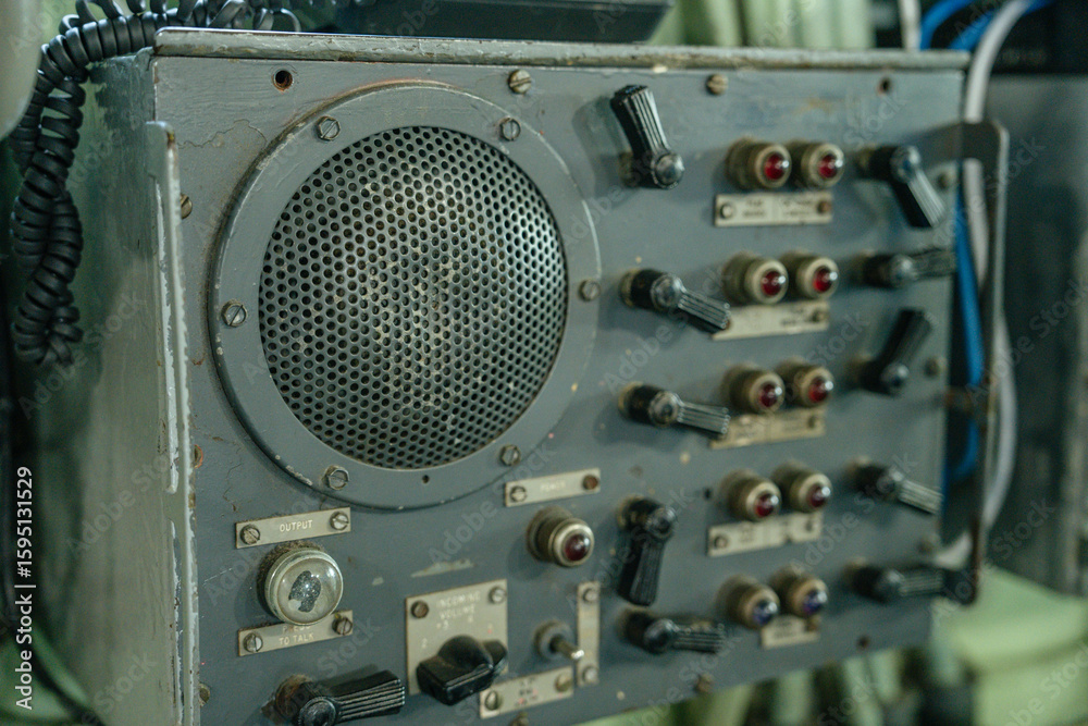Αυτοκόλλητο Close-up of a vintage military speaker unit with multiple labeled switches, knobs, and signal indicators