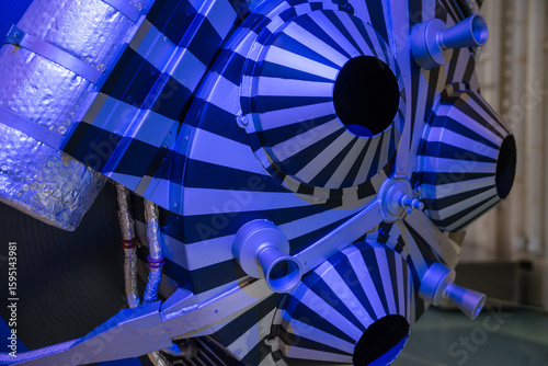 Принти на полотні Extreme close-up of a space capsule's striped thruster system under dramatic blue lighting