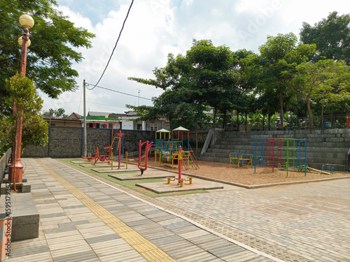 An outdoor recreational playground featuring colorful equipment, open walkways, green trees, a tranquil environment, and a bright, uplifting ambiance suitable for children’s play and relaxation.