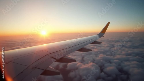 Flying Above Clouds at Sunrise from Airplane Window View