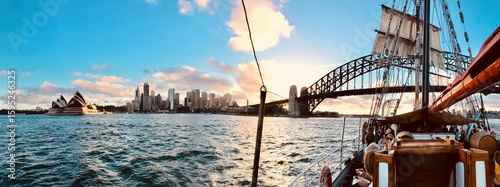 Vue panoramique d’un vieux bateau au coucher de soleil à Sydney avec le pont et l’Opéra en arrière-plan
