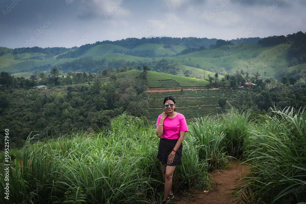 Naklejka premium Indian woman hiking on a scenic trail in Kerala’s lush hills 