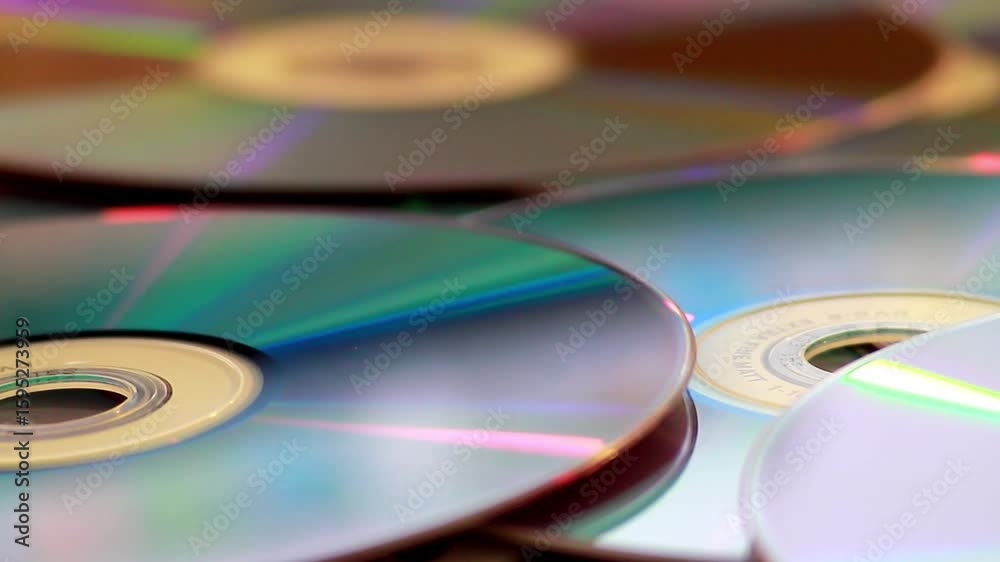 DVD Pile. Ultra HD 4K Close Up Background of Rotating Compact Discs and DVDs with Iridescent Reflective Surfaces and Pink Purple Lighting Effects. round