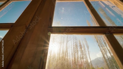 Sunlight streams through a window framing a mountain view
