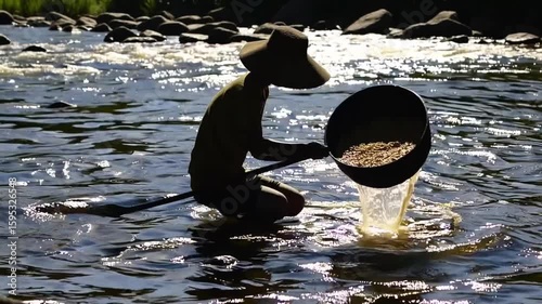 Traditional gold panning technique using wooden liang container to sift through sediment-laden water