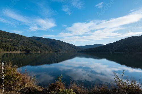 Reflection of the Serene Mountain Lake under the Clear Blue Sky
