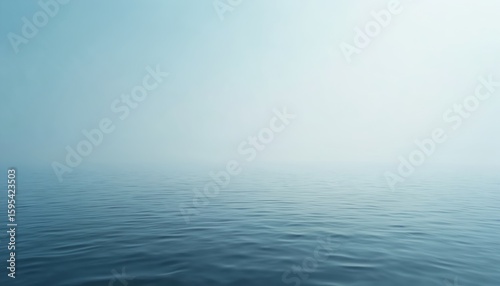 Calm ocean water surface meets hazy sky, creating a vast, expansive horizon. The blue sea shows subtle ripples under soft daylight, offering a peaceful, tranquil, and minimalist natural scene.