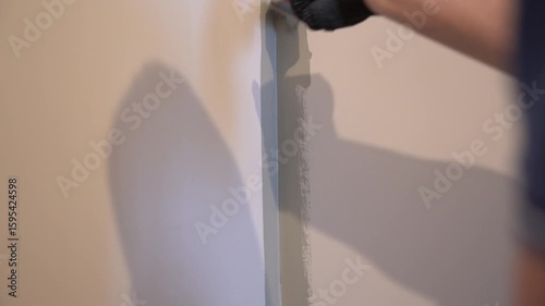 The process of painting walls in which the surface is painted with paint using a brush. For uniform application of paint. Apartment renovation. High quality 4k footage
