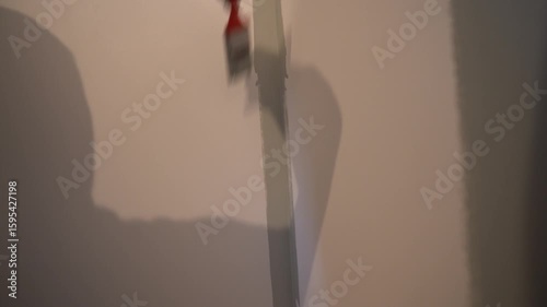 Using a brush, the walls in the room are being painted. For uniform application of paint. Apartment renovation. The wall painting process. High quality 4k footage