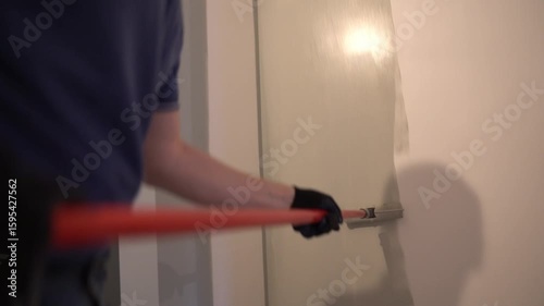 The repairman paints the walls with a pile roller for a perfect wall painting. Roller movement from top to bottom. High quality 4k footage
