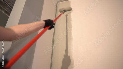Painting walls with a paint roller for perfect wall painting. Roller movement from top to bottom. Grey paint on the surface. High quality 4k footage