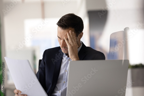 Valokuva Businessman read document with shocked, distressed expression at workplace, facing serious issues, get terrible or troubling news in notice