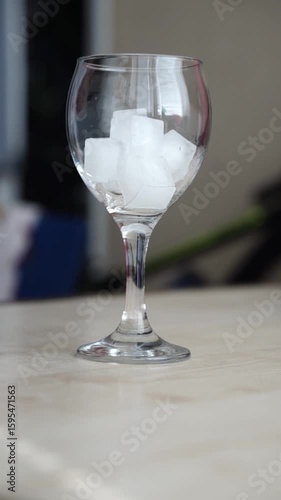 Refreshing Glass of Orange Cocktail with Ice Cubes on Marble Table