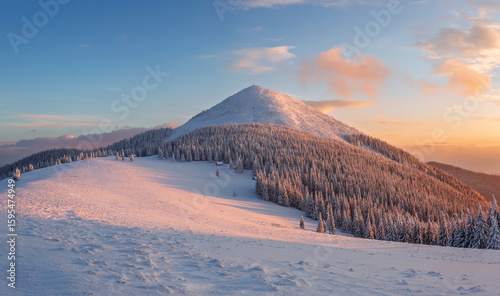 Winter sunset photography. Blue sky with orange clouds. A panoramic view of the covered with snowy mountain peak. Natural landscape. Location place Carpathian, Ukraine, Europe.