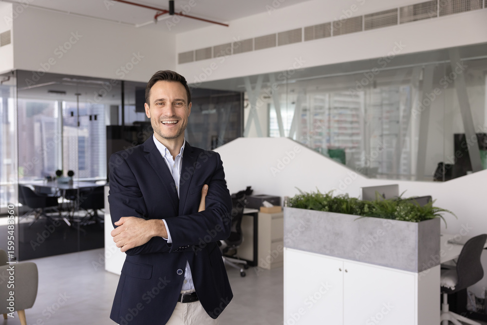 Fototapeta premium Portrait of positive handsome middle-aged businessman, company boss or executive manager posing standing alone in highrise building office, looking at camera, exuding professionalism and competence
