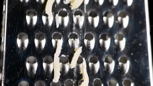 Close-up of a food grater with remnants of cheese on the surface