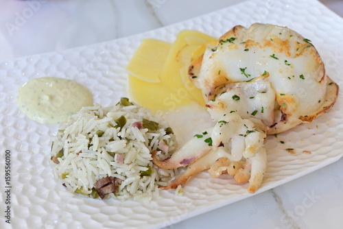 Plato de sepia a la plancha, con patatas panadera, arroz y salsa ali-oli