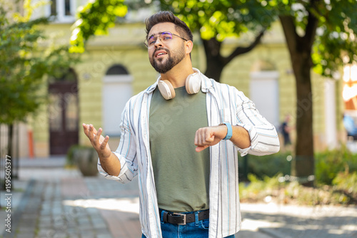 Принти на полотні Serious dissatisfied Caucasian man tourist in glasses standing outdoors looking