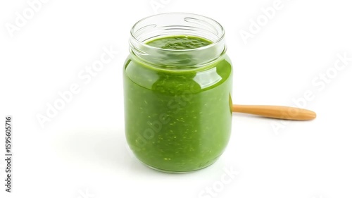 A vibrant green detox smoothie made with spinach, banana, chia seeds, and almond milk, served in a clear glass jar with a wooden spoon on the side. White background highlights the natural color