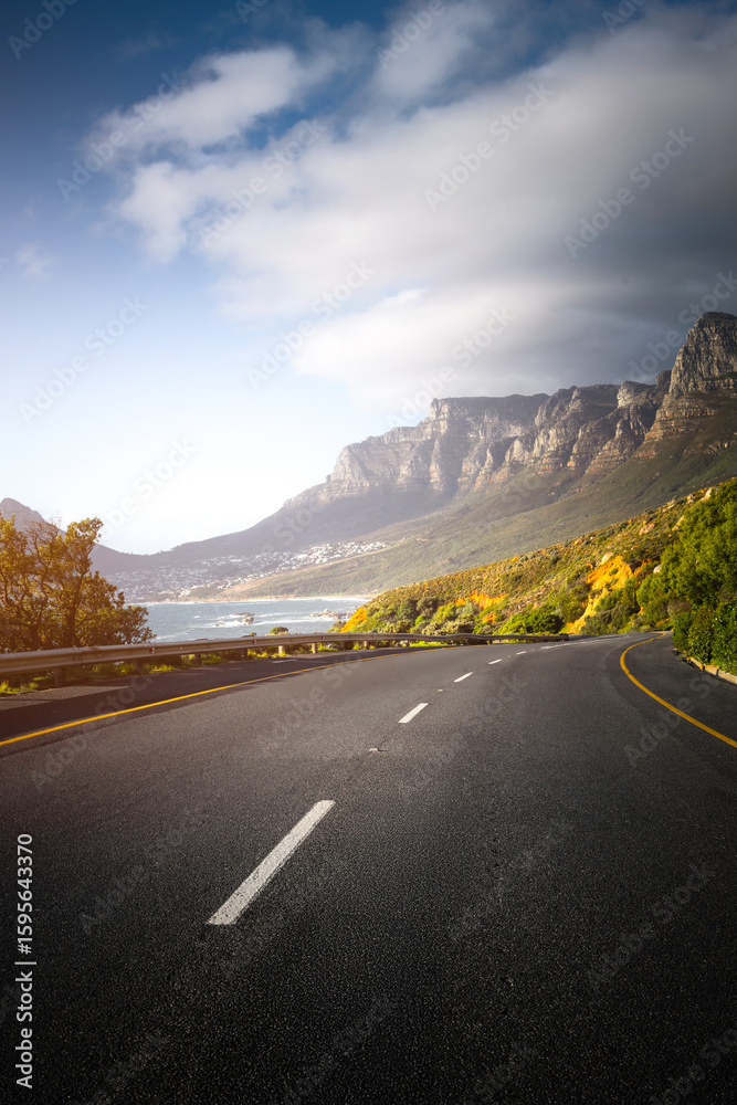 Fototapeta premium Scenic Coastal Road through Cape Town Suburbs with Mountains and Ocean View
