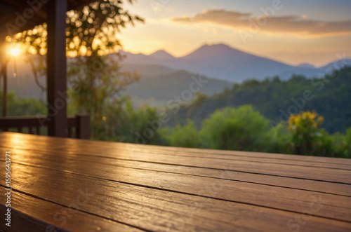 Clean wooden table on villa deck with distant bokeh view of mountain forest landscape under soft golden sunlight providing relaxing visual of peaceful outdoor scene in a natural setting,