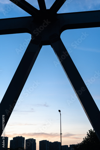  Urban skyline at dusk framed by a bridge structure.