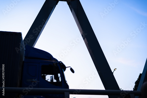  Urban skyline at dusk framed by a bridge structure.