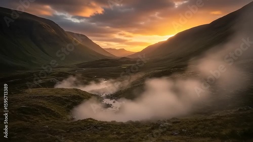 Mountain valley at sunrise with mist