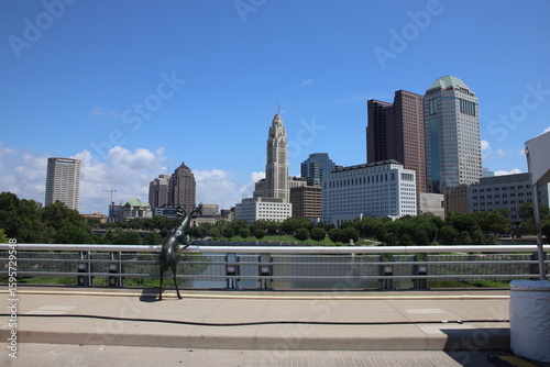 Clean and modern urban skyline of downtown Columbus, Ohio, showcasing architectural diversity, city life, and metropolitan identity. A blend of contemporary and historic buildings under clear skies.