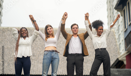 Diverse Group of Happy Teen Friends Raising Hands Together in City