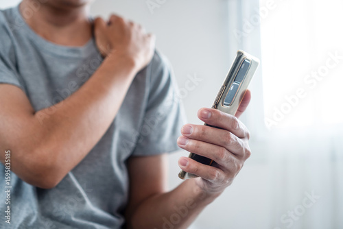  Man Experiencing Neck and Shoulder Pain After Holding His Phone for Too Long Discomfort Caused by Poor Posture, Prolonged Device Use, and Strain on Muscles While Using a Smartphone,