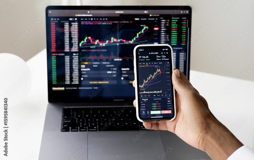 Businessman checking stock market on digital tablet and a desktop computer with stock exchange graph on screen. Financial stock market. Analyzing data in office background. Businessman checking stock market on digital tablet and a desktop computer with stock exchange graph on screen. Financial stock market. Analyzing data in office background.