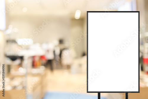 standing mockup white poster with black frame in front of blur boutique fashion shop background for show or present promotion product concept